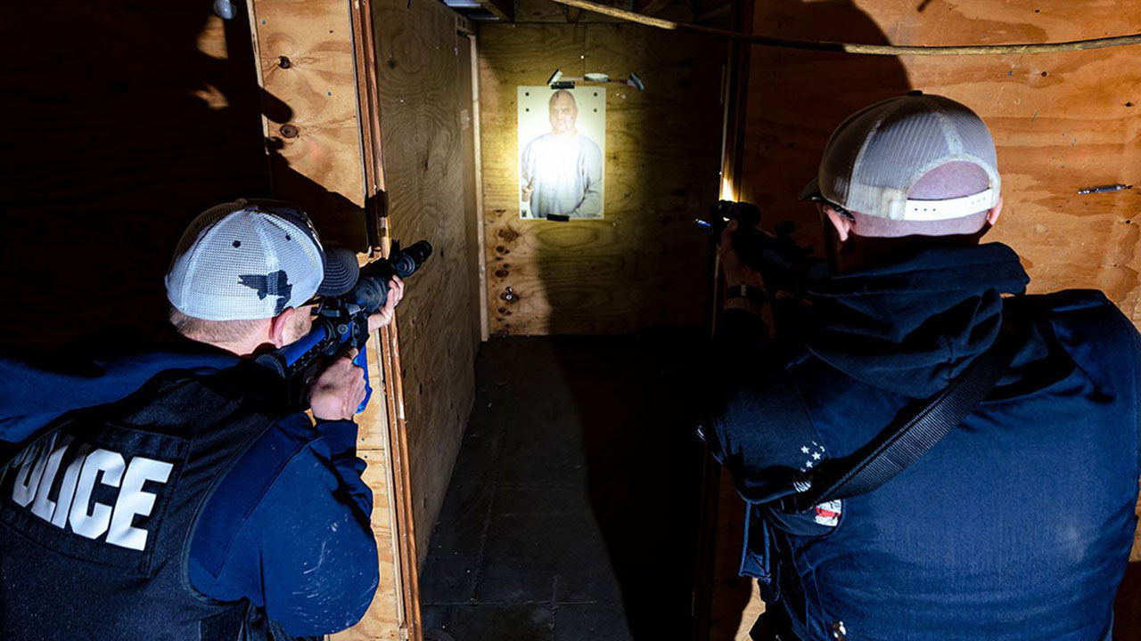 two males outside of small room in advanced high threat training course