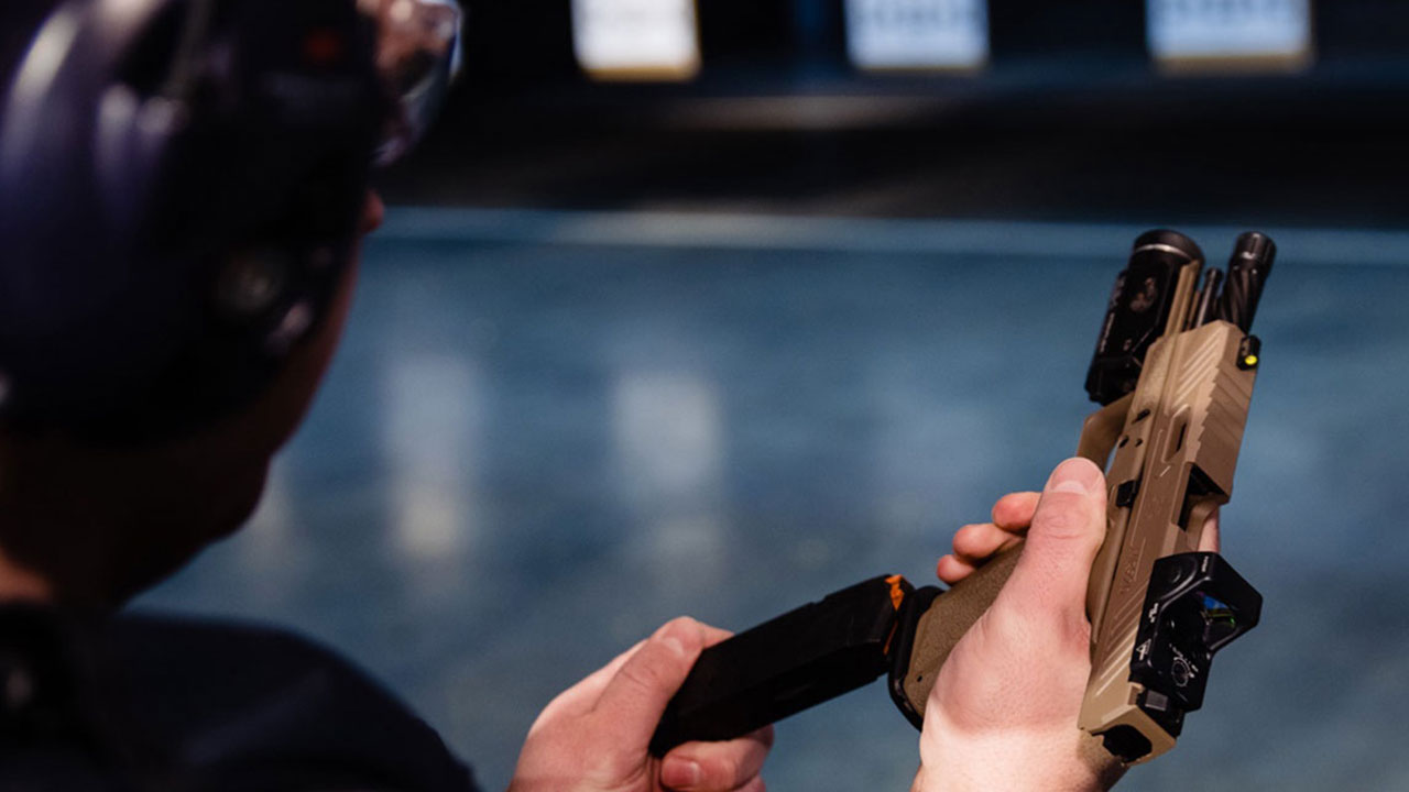 close up of male holding handgun with red dot sight